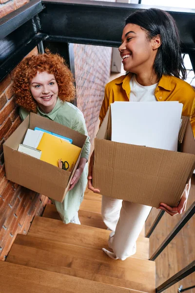 Zwei junge glückliche Frauen ziehen in neues Büro oder Wohnung — Stockfoto