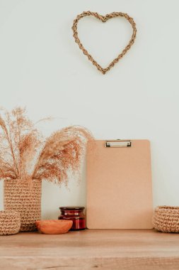 Boş ahşap pano ve kurutulmuş çiçek pampaları. Tahta masadaki yeşil vazoda çimenler ve yazı için boş alan. Konforlu ev dekorunda kullanılan doğal malzemeler. Çevre dostu kavram.