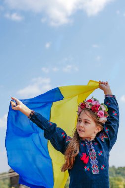 Ulusal kıyafetler ve Ukrayna bayrağı taşıyan bir kız.