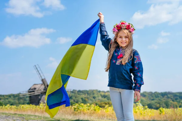 Fille portant des vêtements nationaux et une couronne tenant le drapeau de l'Ukraine — Photo