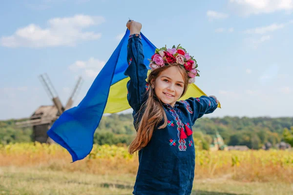 Fille portant des vêtements nationaux et une couronne tenant le drapeau de l'Ukraine — Photo