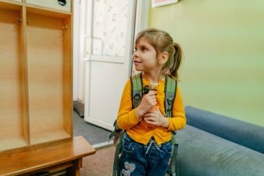 Okuldaki ya da anaokulundaki ilk günüm. Okulun kapısında duran sırt çantalı mutlu küçük kız. Okul konseptine dönelim..