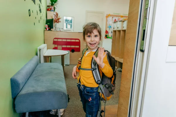 Okuldaki ya da anaokulundaki ilk günüm. Okulun kapısında duran sırt çantalı mutlu küçük kız. Okul konseptine dönelim..