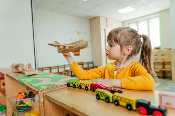 Anaokulunda ya da çocuk yuvasında tahta ovalarla oynayan küçük bir kız. Montessori eğitim kavramı.