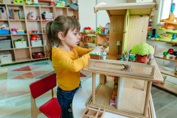 Little Girl Playing Wooden House Toy Furniture Kindergarten Childcare Centre — Zdjęcie stockowe