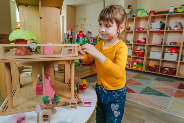 Little Girl Playing Wooden House Toy Furniture Kindergarten Childcare Centre — Zdjęcie stockowe