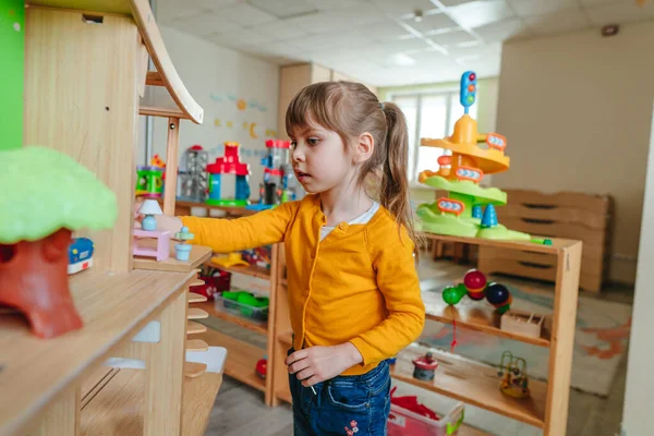 Little Girl Playing Wooden House Toy Furniture Kindergarten Childcare Centre — Zdjęcie stockowe