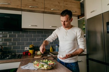 Pişirme kabına balık koyan adam aşçı için çipura ve sebze hazırlıyor. Seçici odak.