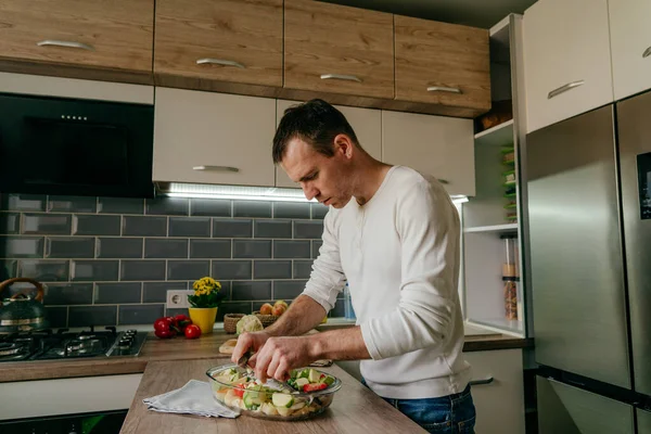 Pişirme kabına balık koyan adam aşçı için çipura ve sebze hazırlıyor. Seçici odak.