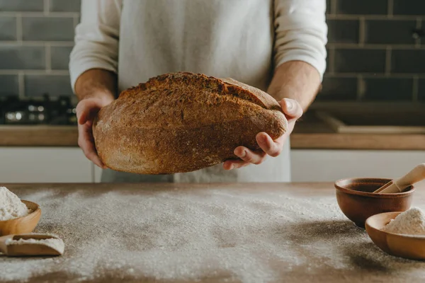 Невпізнаваний Молодий Чоловік Фартусі Тримає Домашній Цільний Зерновий Хліб Вибірковий — стокове фото