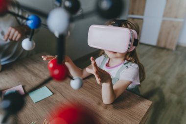 Küçük kız moleküler yapıyı öğrenmek için sanal gerçeklik gözlüğü kullanıyor. Modern eğitim bilim konsepti. Seçici odak.