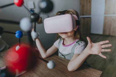 Küçük kız moleküler yapıyı öğrenmek için sanal gerçeklik gözlüğü kullanıyor. Modern eğitim bilim konsepti. Seçici odak.