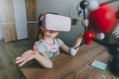 Küçük kız moleküler yapıyı öğrenmek için sanal gerçeklik gözlüğü kullanıyor. Modern eğitim bilim konsepti. Seçici odak.