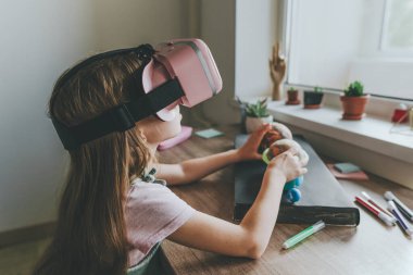 Güneş sistemi gezegenlerini öğrenmek için evde sanal gerçeklik gözlüğü kullanan küçük bir kız. Modern eğitim bilim konsepti. Seçici odak.