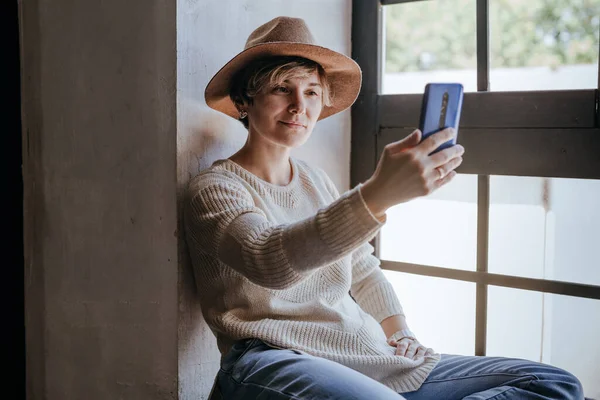 Jeune Femme Utilisant Smartphone Ayant Appel Vidéo Assis Près Fenêtre — Photo