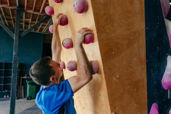 Genç Adam Bir Spor Salonunda Kaya Tırmanışı Eğitim Tahtasında Asılı — Stok fotoğraf
