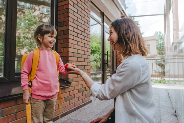 Mother Leading Her Daughter School Giving Apple Young Woman Little — Foto de Stock