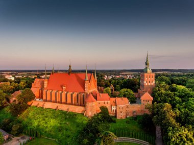 Warmia 'daki Frombork şehrinin harika manzarası. Gün batımında ağaçların arasında Katedral Tepesi. Nicolaus Kopernik 'in yaşadığı şehir..