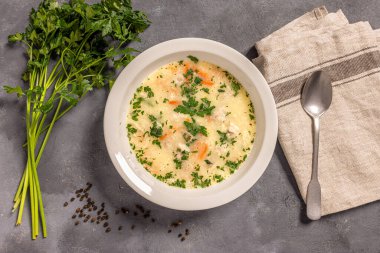 Beyaz tabakta servis edilen lezzetli tavuk ve et çorbası.