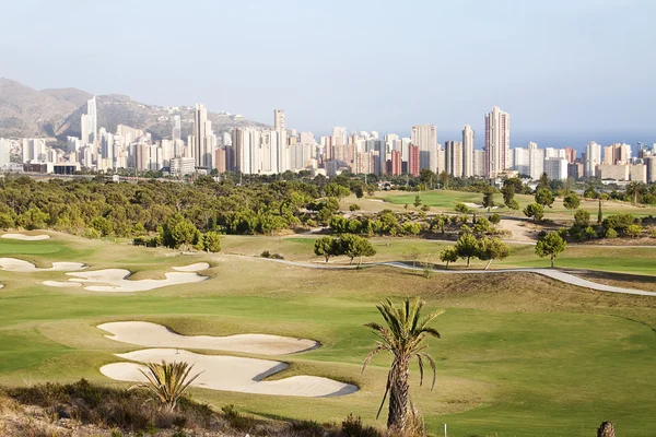 Panoramisch van wolkenkrabber stad met golf veld in benidorm, Spanje — Stockfoto