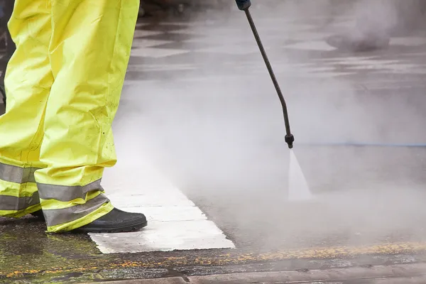 Dělník čištění ulic se tlak vody Royalty Free Stock Obrázky