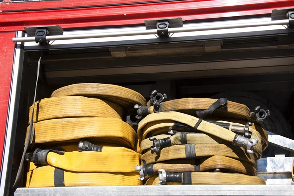 Hengerelt és sárga Tűzoltó tömlők, a tüzet egy teherautó — Stock Fotó