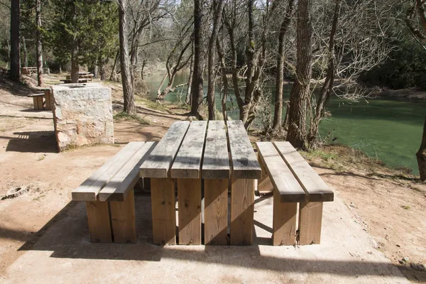 Дерев'яні пікніку таблиці поруч річка в районі природи в Іспанії — стокове фото