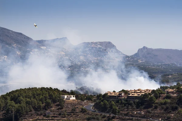 Avion dans un feu brûlant forêt de montagne et village, danger pour — Photo