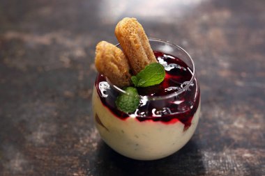 Panna cotta bir fincanda. Tatlı meyve tatlısı. Meyveli kremalı hafif yoğurt tatlısı ve sünger keki. Tabakta aperatif yemek, yemek fotoğrafçılığı. Gıda arkaplanı.