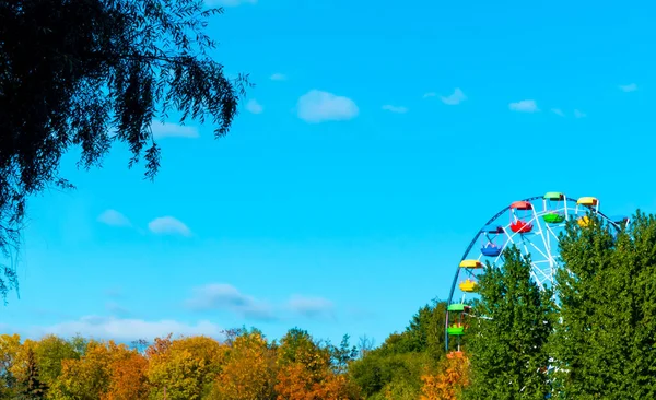 Bir Lunaparkın Manzarası Dönme Dolabın Tepesi Ağacın Tepesinde Mavi Bir — Stok fotoğraf