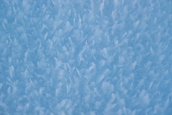 Textura de neve com flocos de neve close-up. Imagem macro azul de uma deriva de neve abstrata. Cristal neve textura mínima puro. Inverno paisagem fundo. — Fotografia de Stock