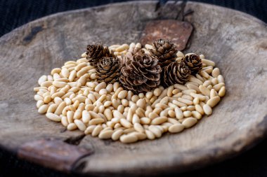 Ahşap kasede çam fıstığı ve kozalak. Çimento kavramı