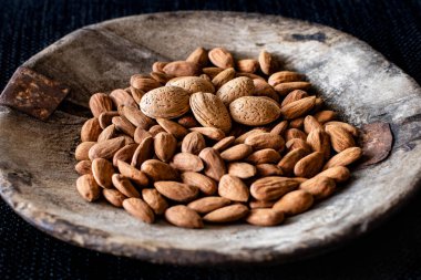 Eski ahşap kasede bir sürü badem var. Kurutulmuş fındık konsepti. 