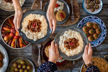 Aile üyelerinin elinde birçok çeşit yiyecek var. Adı Hunkar Begendi olan yerel yiyecekler. Havan topu konsepti. Yerel ev yapımı gıdaların çeşitliliği.   