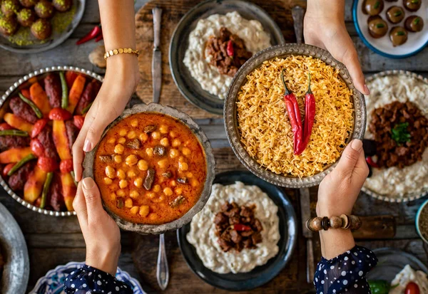 Aile üyelerinin elinde birçok çeşit yiyecek var. etli nohut ve bulgur pilavi adında yerel yiyecekler. Havan topu konsepti. Yerel ev yapımı gıdaların çeşitliliği.   