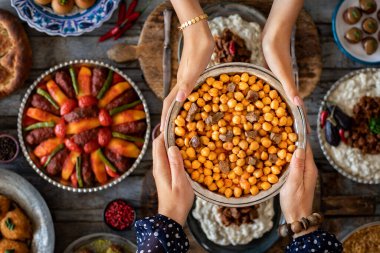 Aile üyelerinin elinde birçok çeşit yiyecek var. etli nohut adında yerel yemek. .