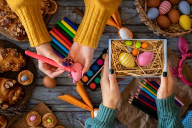 Paskalya için yumurta boyuyorum. Masada bir sürü yumurta ve boya var.