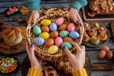 Paskalya çöreği ve paskalya yumurtası olan iki kadının elleri. Paskalya coregii . Masa üstü görünümlü Paskalya konsepti. 