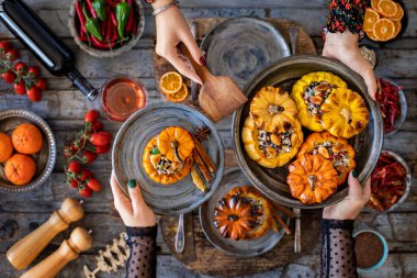 Celebration dinner with rose wine and mini stuffed pumpkins. Dining table with vegan foods. 