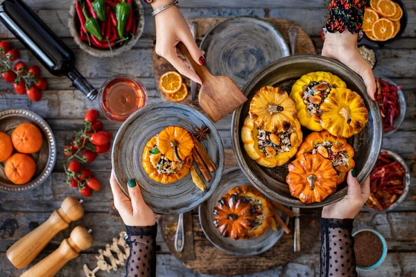 Celebration dinner with rose wine and mini stuffed pumpkins. Dining table with vegan foods.