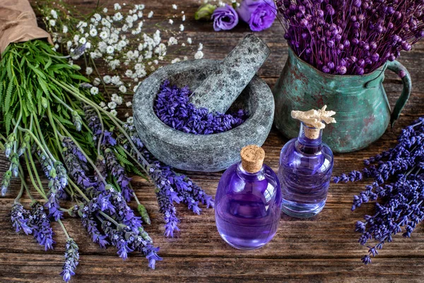 Fresh lavenders and lavender oil with spa materials on the table. Skin and face beauty oils and equipments.