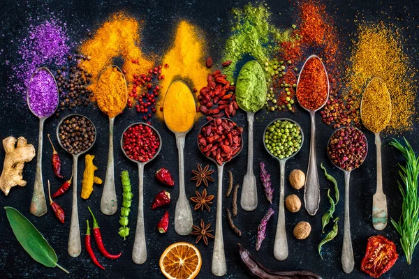 Masanın üzerinde çeşitli baharatlar ve kurutulmuş meyveler var. Baharatlı arka plan kavramı.