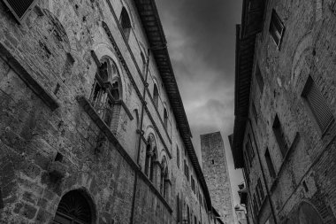 San Gimignano, Toskana 'da bir şehirdir. 13. yüzyıl duvarlarıyla çevrili olan tarihi merkezinin en önemli parçası Piazza della Cisterna 'dır. Ortaçağ kulelerinin siluetinde Torre Grossa taşın altında duruyor..