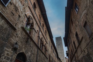 San Gimignano, Toskana 'da bir şehirdir. 13. yüzyıl duvarlarıyla çevrili olan tarihi merkezinin en önemli parçası Piazza della Cisterna 'dır. Ortaçağ kulelerinin siluetinde Torre Grossa taşın altında duruyor..