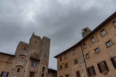 San Gimignano, Toskana 'da bir şehirdir. 13. yüzyıl duvarlarıyla çevrili olan tarihi merkezinin en önemli parçası Piazza della Cisterna 'dır. Ortaçağ kulelerinin siluetinde Torre Grossa taşın altında duruyor..