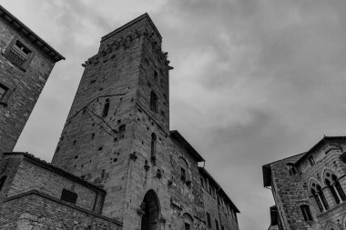 San Gimignano, Toskana 'da bir şehirdir. 13. yüzyıl duvarlarıyla çevrili olan tarihi merkezinin en önemli parçası Piazza della Cisterna 'dır. Ortaçağ kulelerinin siluetinde Torre Grossa taşın altında duruyor..