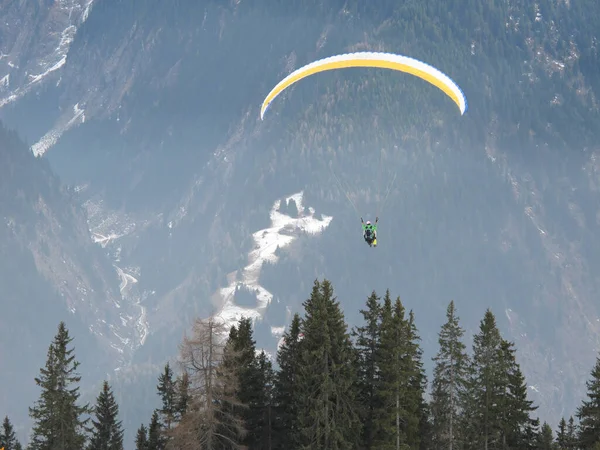 冬に2人の男が谷をパラグライダーで飛び — ストック写真