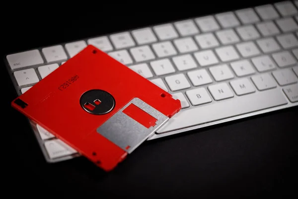 赤いフロッピーディスクは白いキーボードにあり — ストック写真