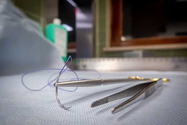 Egy Sebészeti Varratot Szorítanak Egy Tűtartóba Mellette Egy Csipesz Található — Stock Fotó