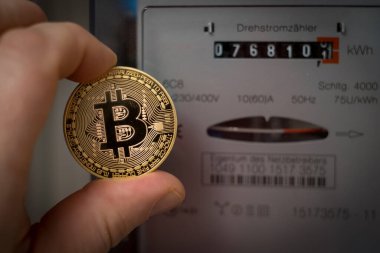 Bir el bitcoin 'i üç aşamalı bir metrenin önünde tutuyor.